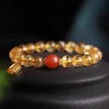 Natural red agate bracelet with gold-tone setting showing polished gemstone beads