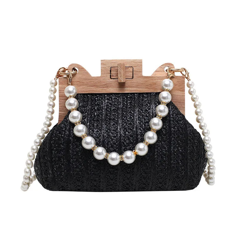 Women's woven straw shoulder bag with pearl chain detail showing horizontal square shape and internal compartments