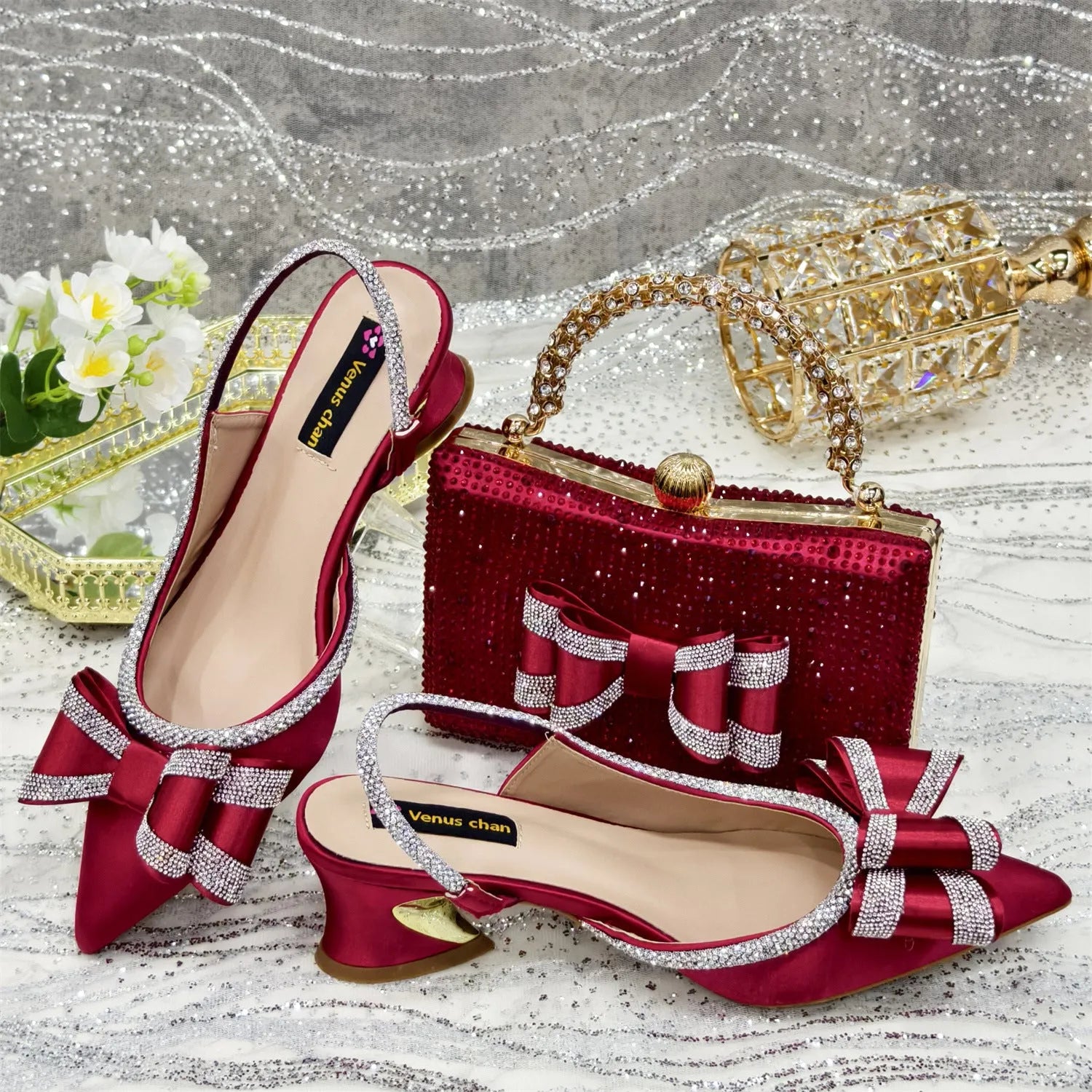 Women's pointed toe sandals with square rhinestone buckle and matching bag on a mid heel.