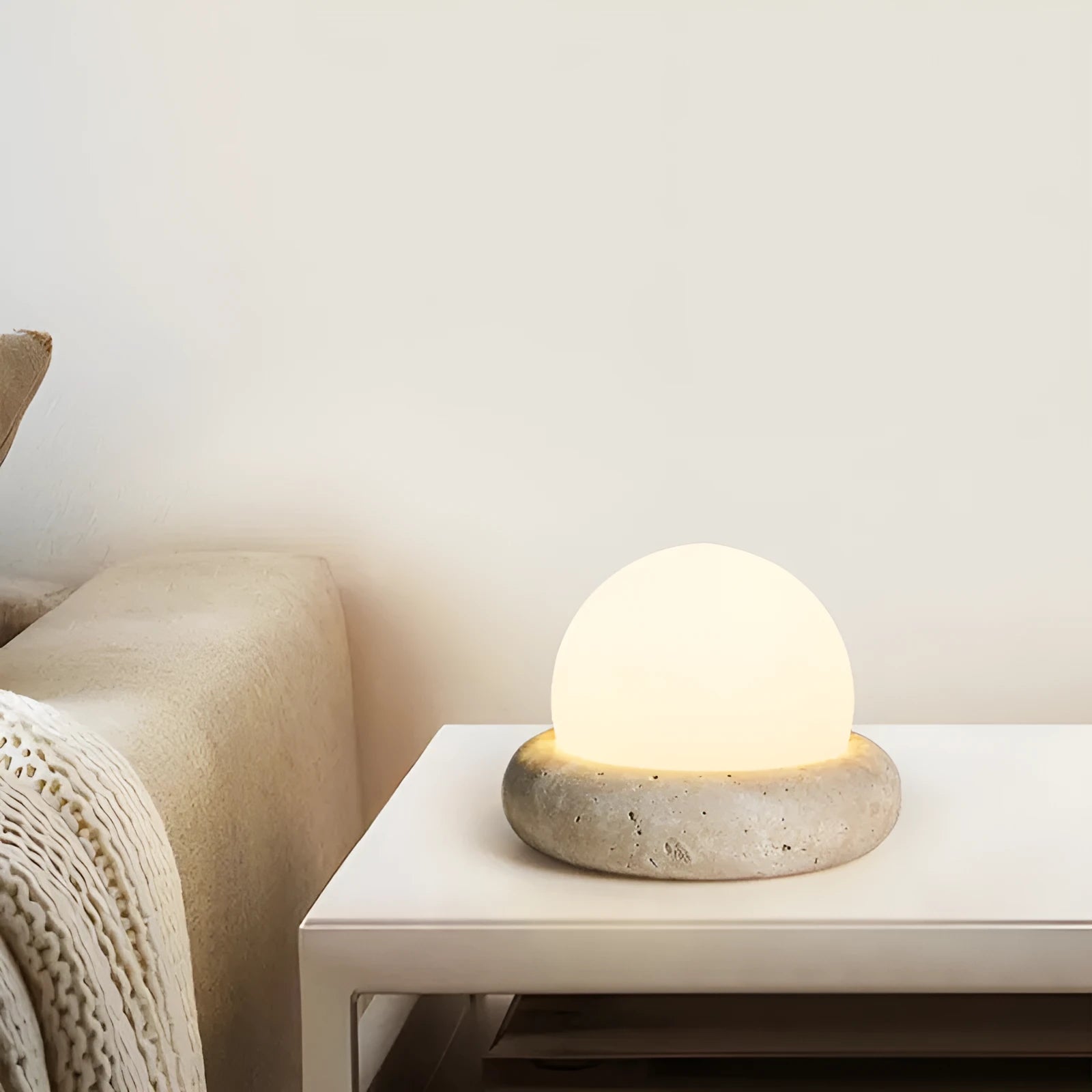 Cream coloured modern bedside night lamp with remote control on wooden table