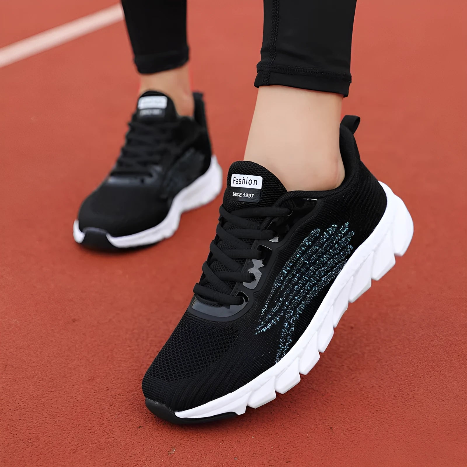 Women's low-top black and white running sneakers with cross-strap detail and MD sole.