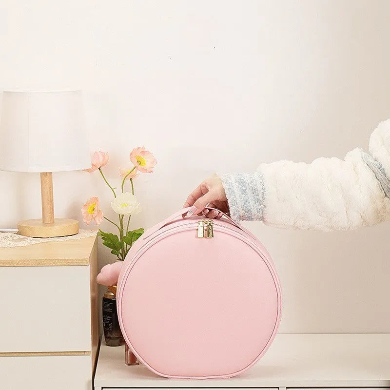 Round black PU leather makeup bag with open lid showing internal LED mirror and cosmetic partitions.