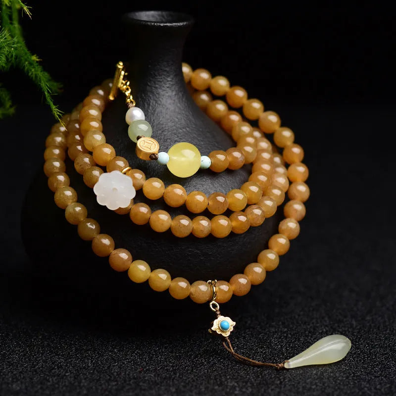 Women's jade bracelet with 6mm round beads in clear water green featuring leaf accents