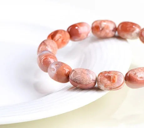 Natural cherry agate barrel bead bracelet with Ruyi charm showing 10x14mm beads