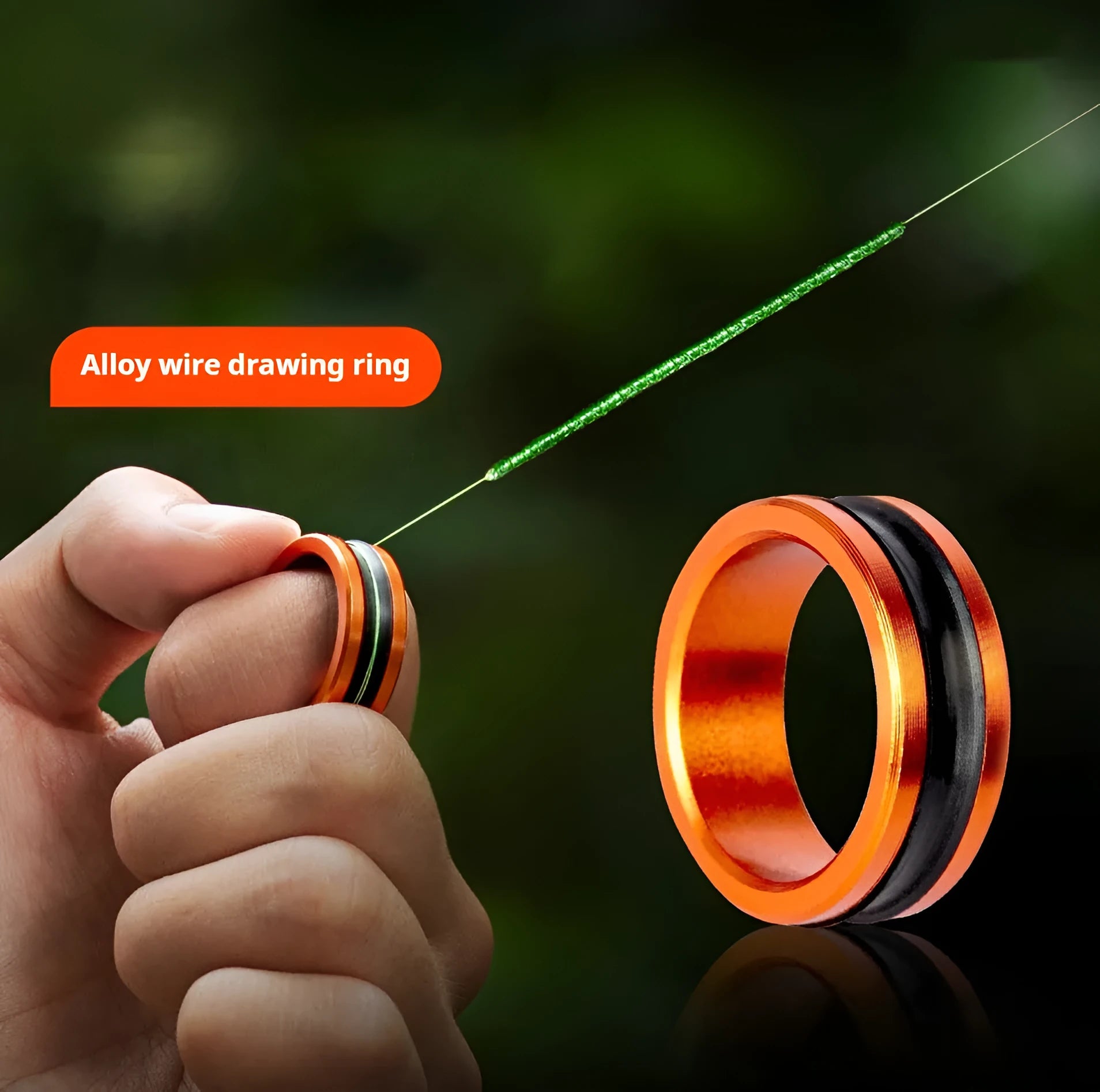 Orange and silver alloy fishing hand guard pull loop tool on a non-slip surface.