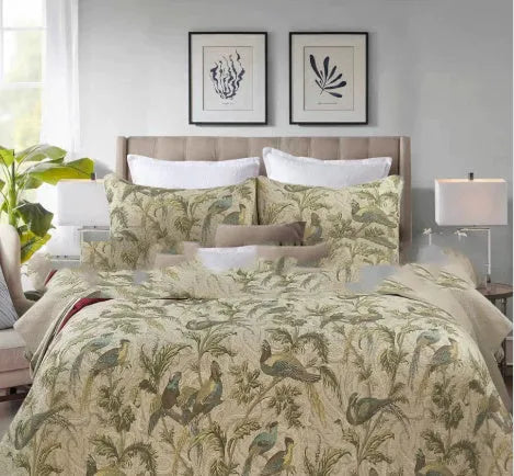 Blue American floral and bird pattern quilted cotton bedspread laid flat on a bed.
