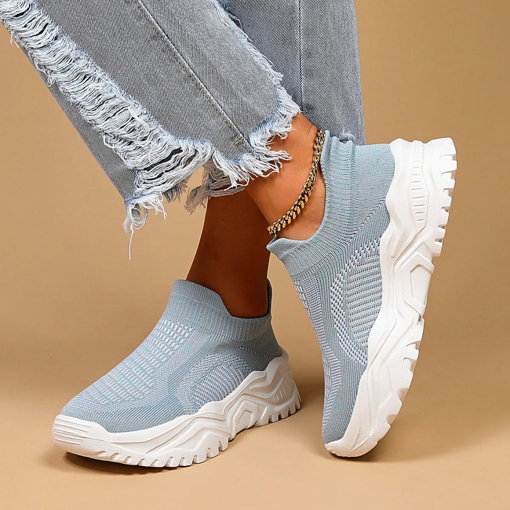 Light blue women's mesh slip-on sports shoes with a round toe and mid heel on a white background.