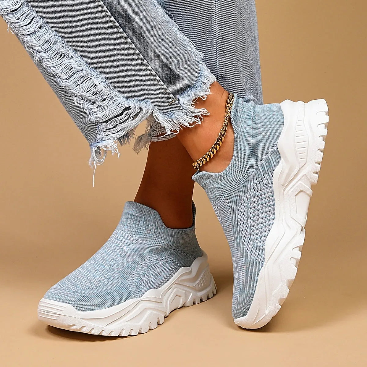 Light blue women's mesh slip-on sports shoes with a round toe and mid heel on a white background.