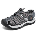 Women's black leather mesh toe box sandals with elastic band and rubber sole on a beach