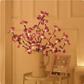 Pink LED orchid branch decorative light on a bedside table.