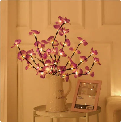 Pink LED orchid branch decorative light on a bedside table.