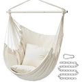 Folding canvas hammock in beige with seat cushion and three-section iron pipe on a garden background