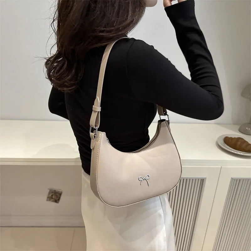 Small dumpling-shaped PU leather women's shoulder bag in khaki with a single strap and zip closure.