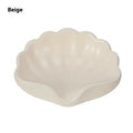 White plastic shell-shaped soap dish with drainage holes on a bathroom countertop