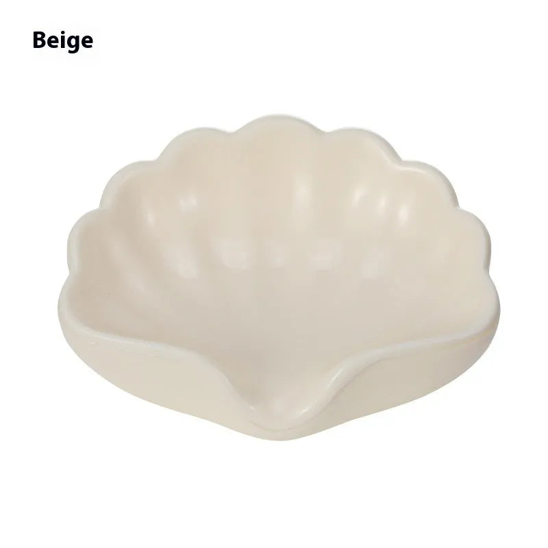 White plastic shell-shaped soap dish with drainage holes on a bathroom countertop