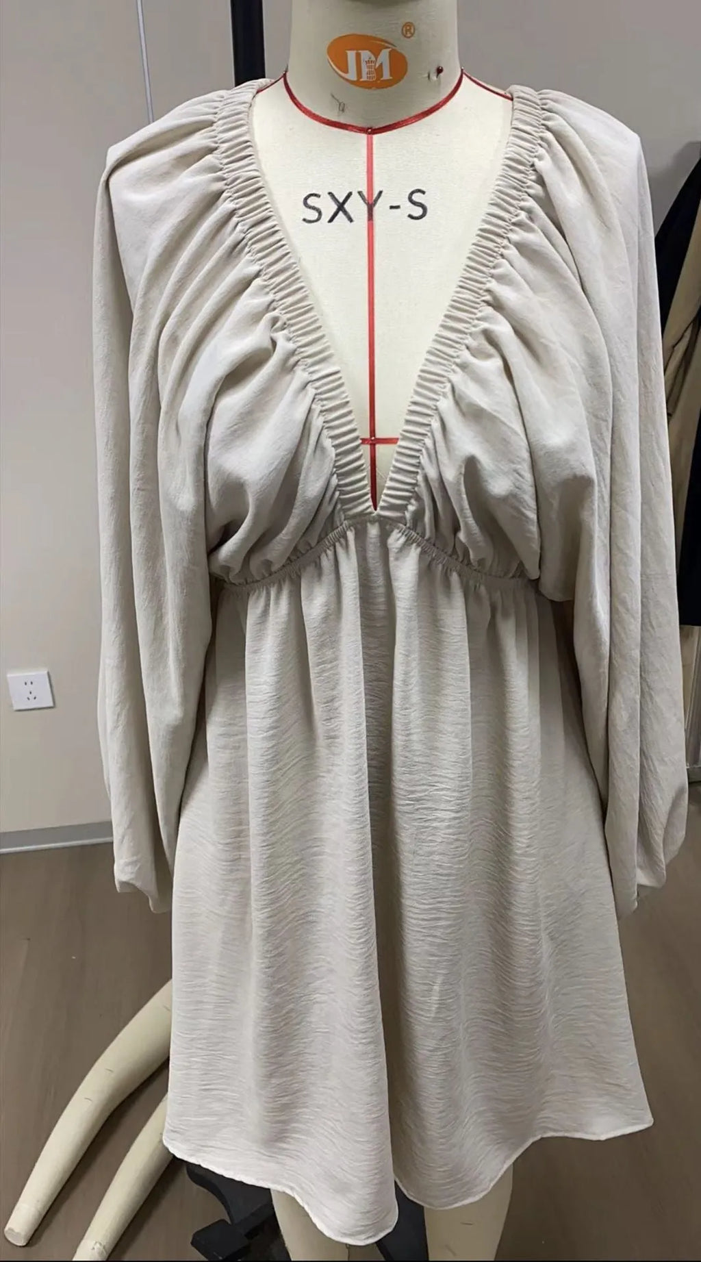 Women's apricot V-neck dress with long puff sleeves and a flounced swing skirt, mid-waist fit.