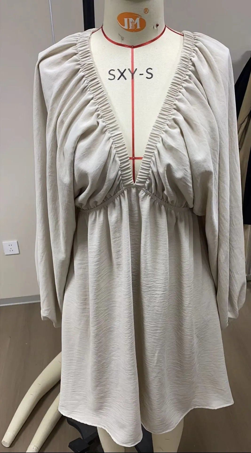 Women's apricot V-neck dress with long puff sleeves and a flounced swing skirt, mid-waist fit.
