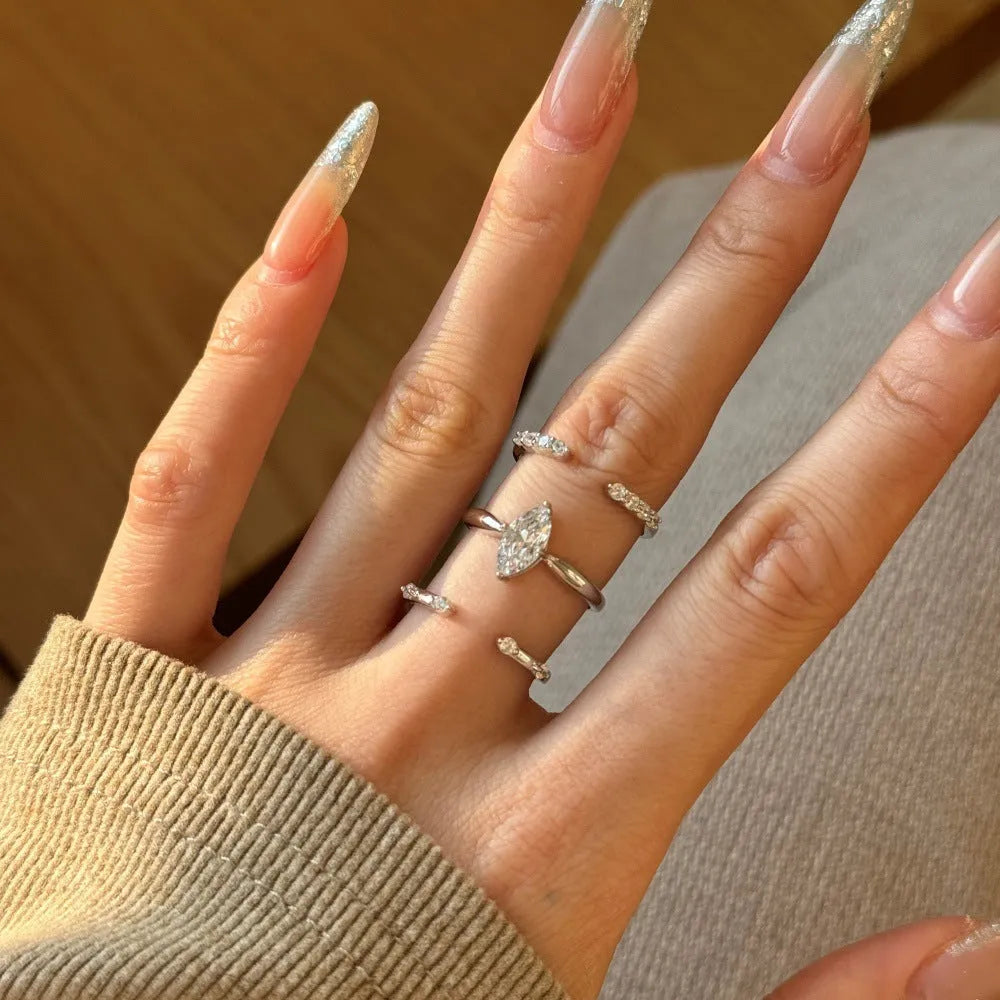 Sterling silver open ring with irregular wave design and adjustable opening on female hand