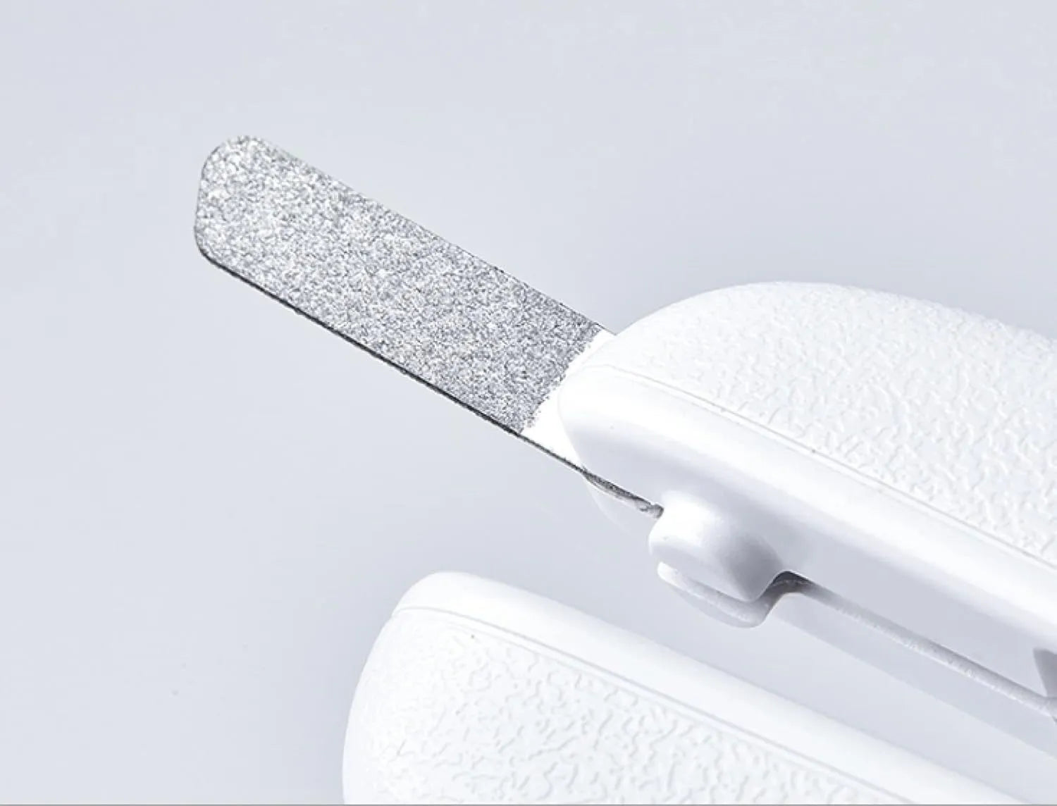 White pet nail clippers with LED light, transparent guard, and built-in file for cats and dogs.
