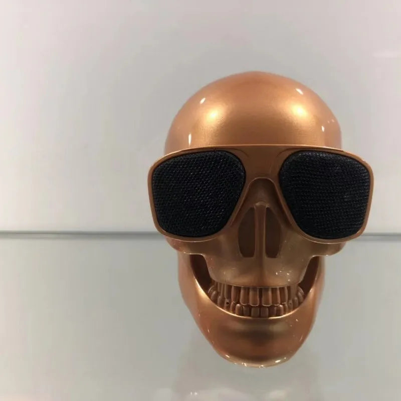 Small skull-shaped wireless Bluetooth speaker in black, portable with button controls and USB charging