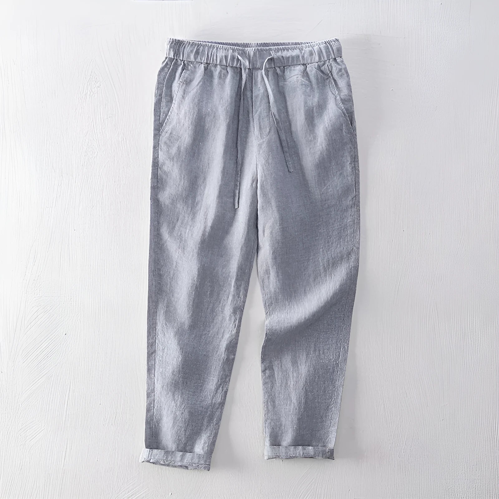 Men's straight leg linen trousers in light grey colour, showing mid waist and tailored fit.