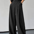 Men's black vertical striped pleated casual trousers laid flat.