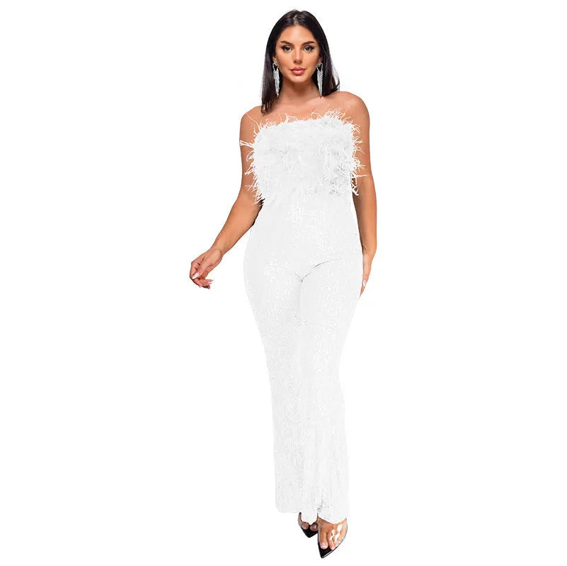 A woman models a black sleeveless, backless jumpsuit with flared legs and sequin details.