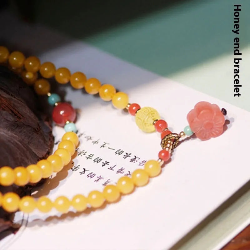Yellow amber bracelet with 5mm round beads and an animal zodiac charm on a white background.