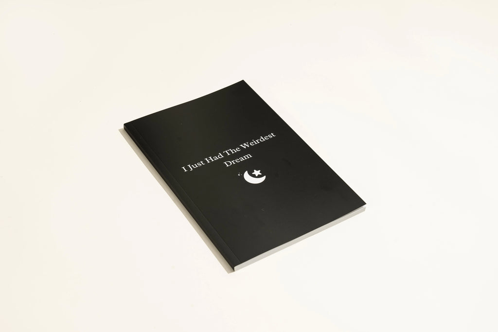 Black A5 hardcover dream journal notebook with lined paper and a ribbon bookmark.