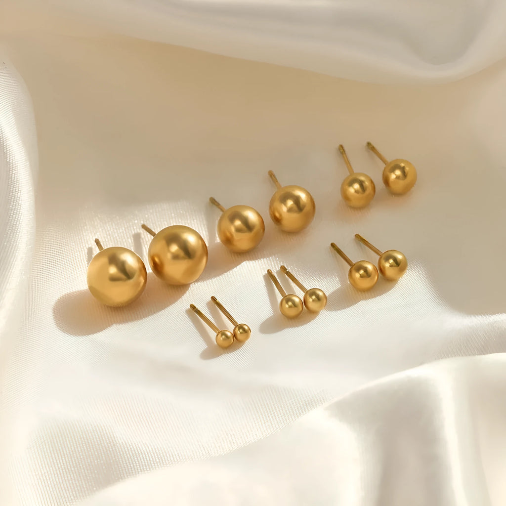 Simple stainless steel stud earrings with geometric sphere design in gold colour on white background