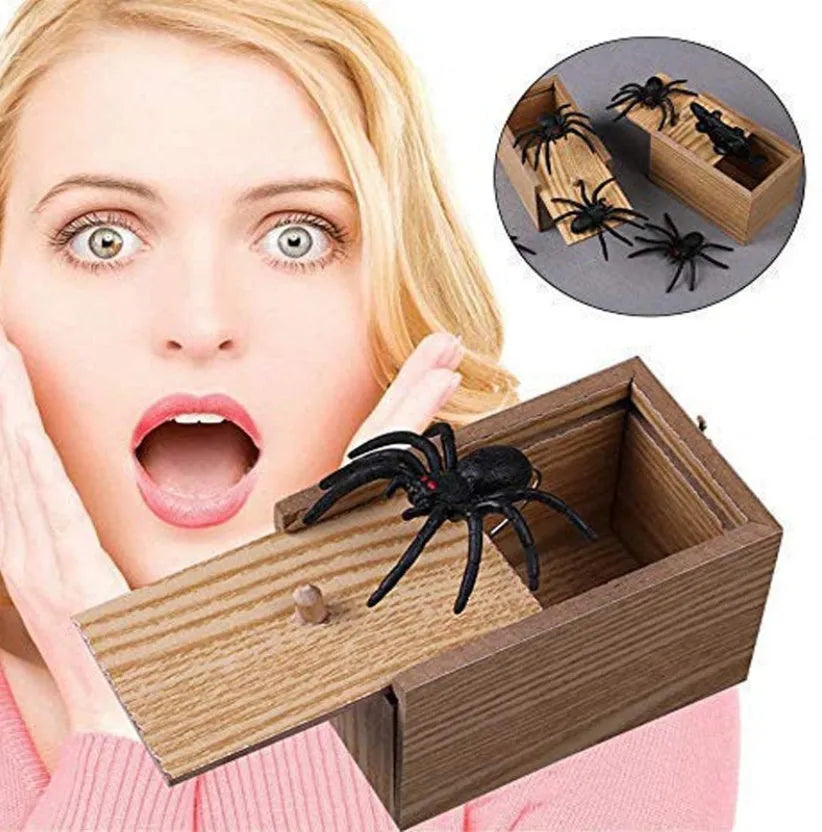 Wooden prank scare box open showing a lifelike spider figurine on a spring, next to the box lid.