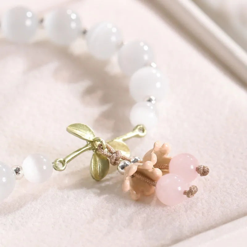 Women's beaded bracelet with diamond-shaped cat's eye opal stones in multiple colour options on a wrist.