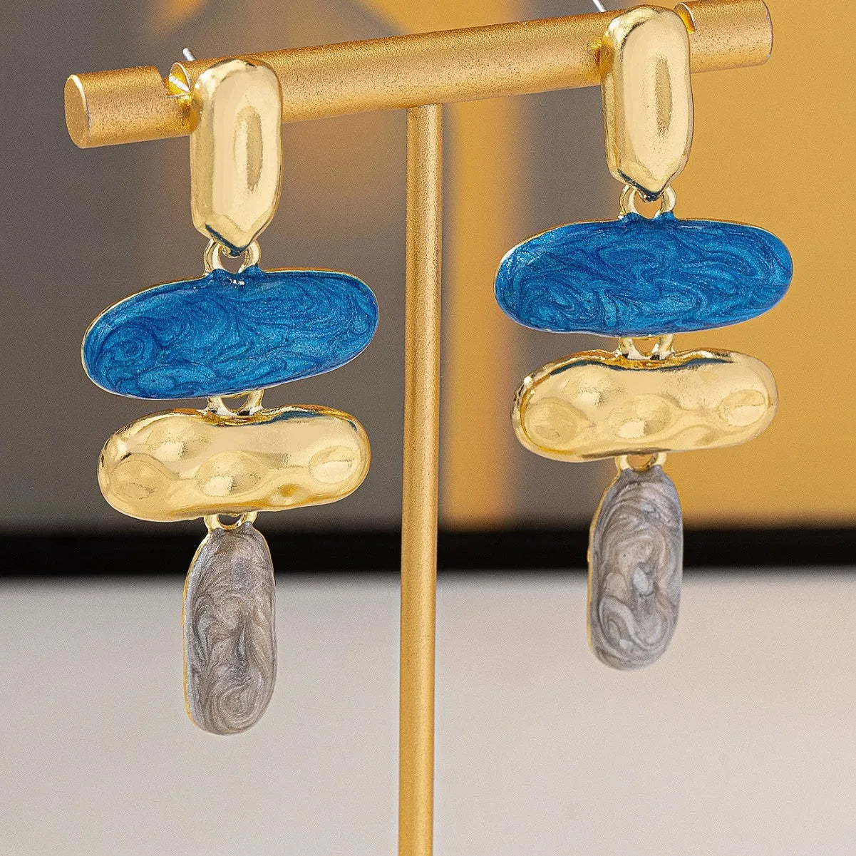 A pair of geometric multicolour stud earrings for women on a plain background.