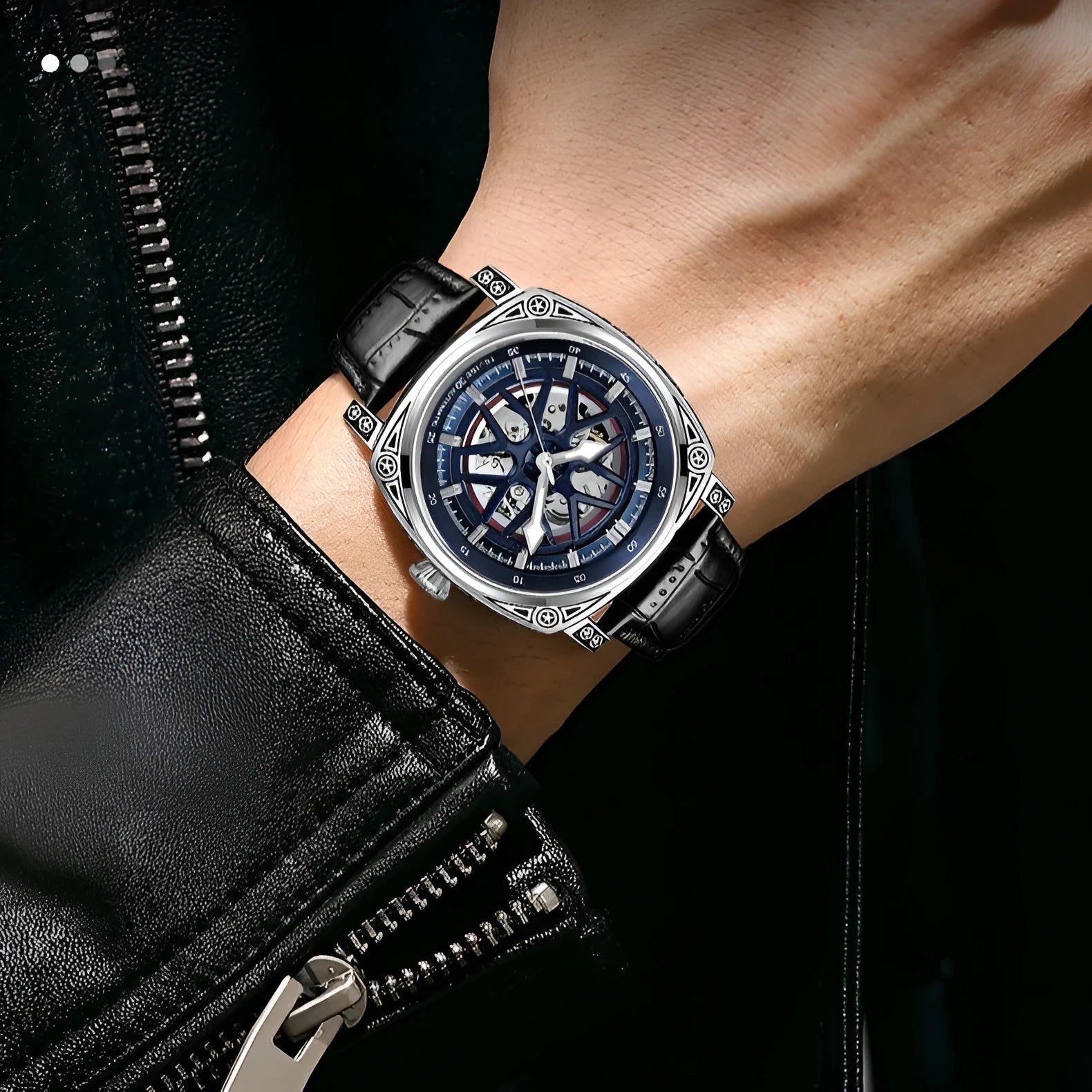 Men's stainless steel automatic watch with a leather strap on a wrist.