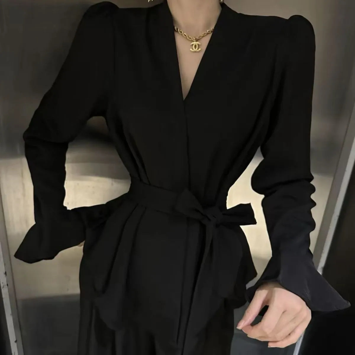 Women's black polyester shirt with a French-style irregular collar and long bell sleeves.
