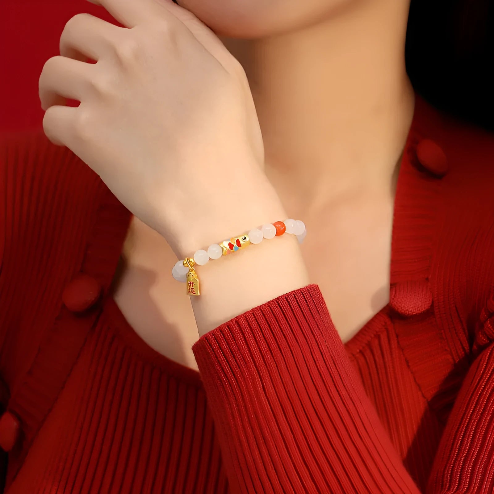 Close-up of a women's sterling silver bracelet with a koi fish cold enamel design and a natural Hetian jade component.