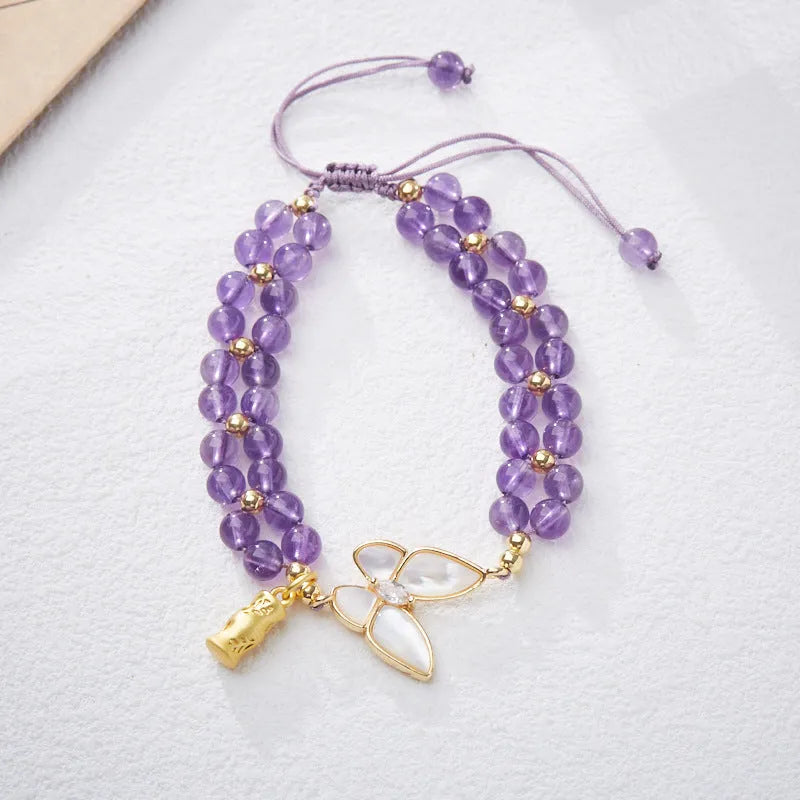 Women's woven bracelet with 6mm aquamarine beads and butterfly design on a wrist.