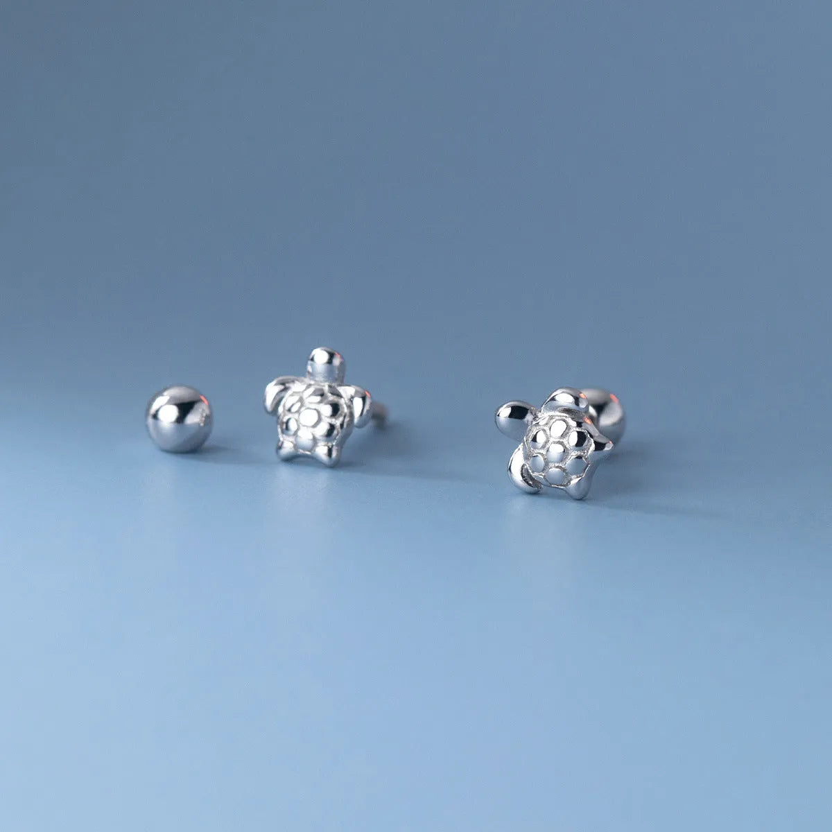 Small 925 sterling silver turtle stud earrings with thread line detail, shown in gold and silver colour options