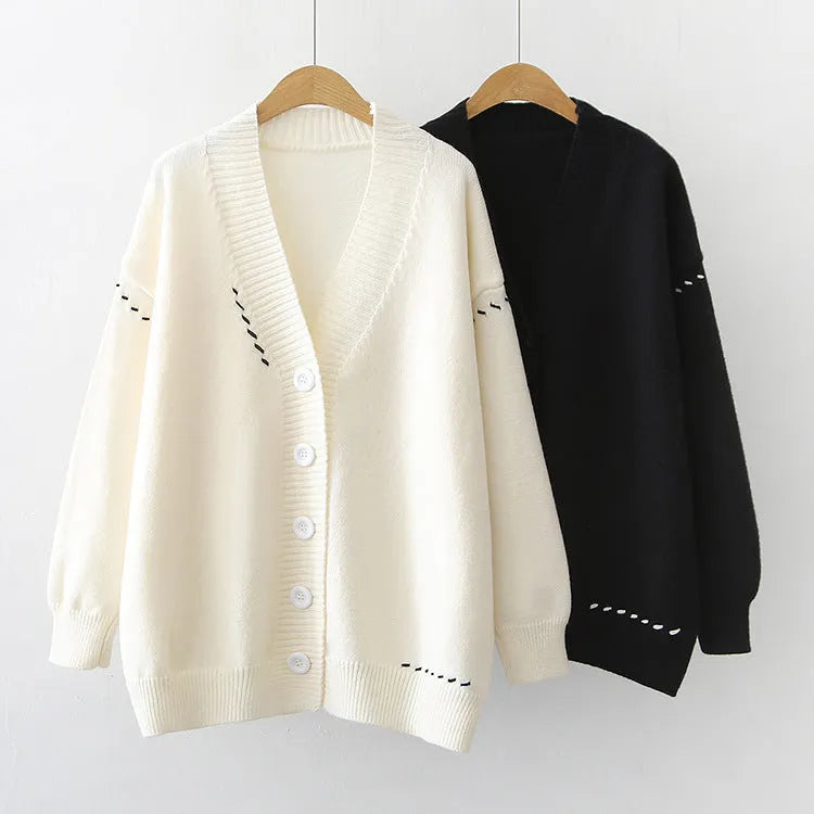 Women's loose-fit knitted cardigan coat in black, shown as a long-sleeve layering piece.