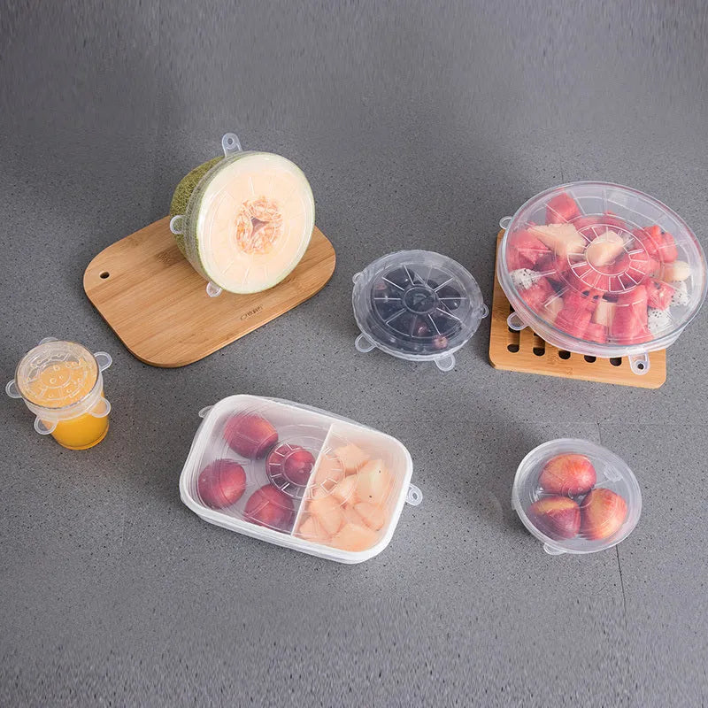 Set of six colourful silicone stretch food covers in different sizes on a kitchen counter.