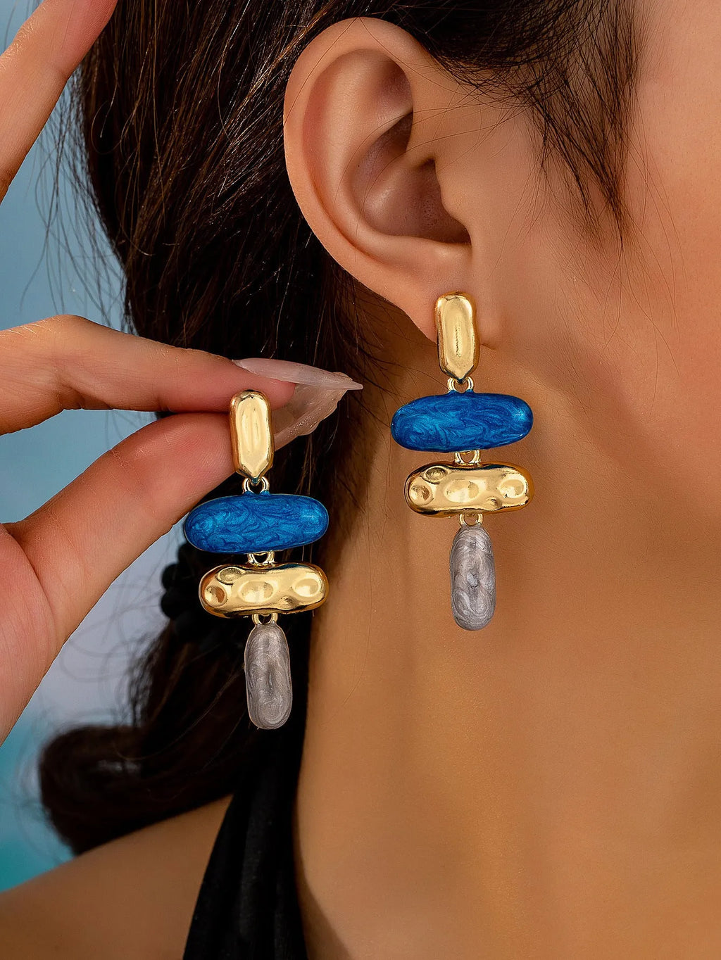 A pair of geometric multicolour stud earrings for women on a plain background.