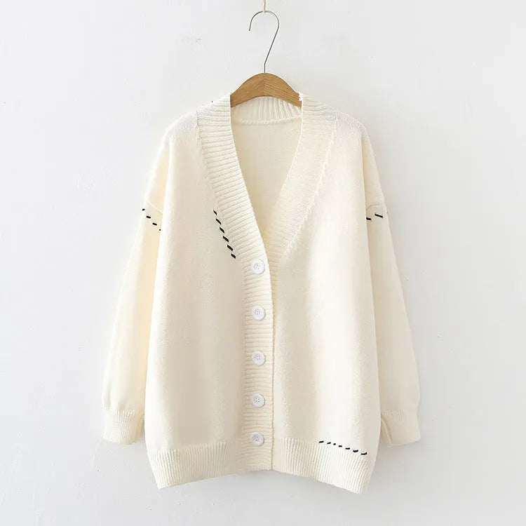 Women's loose-fit knitted cardigan coat in black, shown as a long-sleeve layering piece.