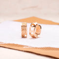 Rose gold women's earrings with three hollowed heart charms on a circular setting.