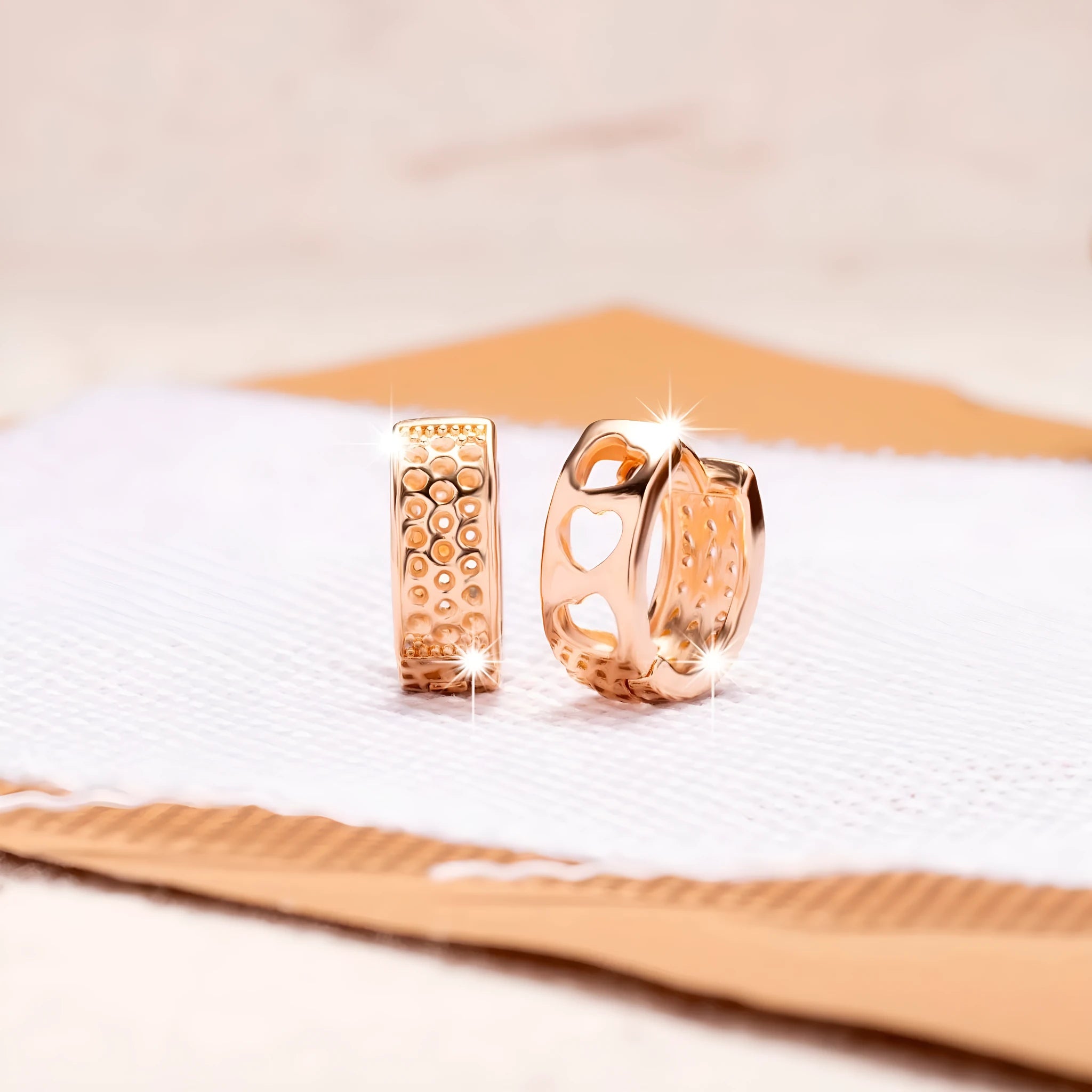 Rose gold women's earrings with three hollowed heart charms on a circular setting.