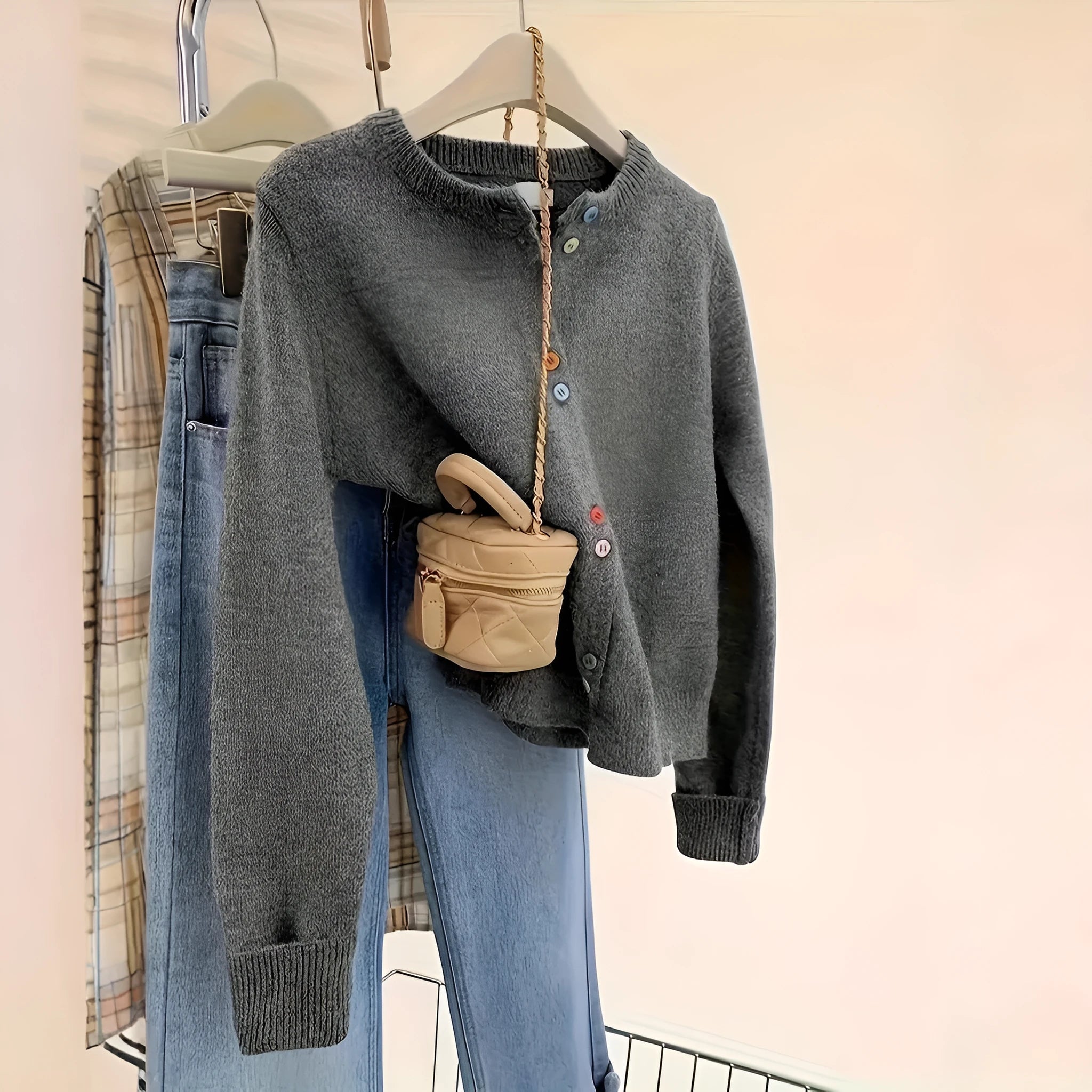 Dark grey women's polyester cardigan sweater with buttons and long sleeves on a hanger.
