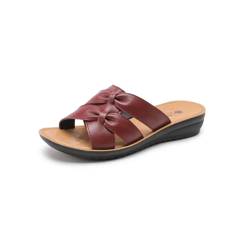Women's beige cowhide slippers with a soft sole and synthetic leather lining, shown in a sandal style.