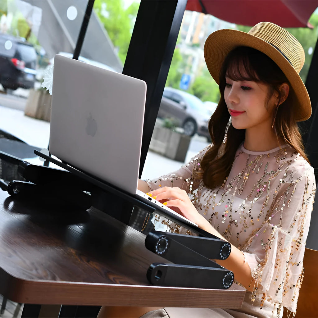 Folding metal laptop desk with cooling holes in black colour on bed