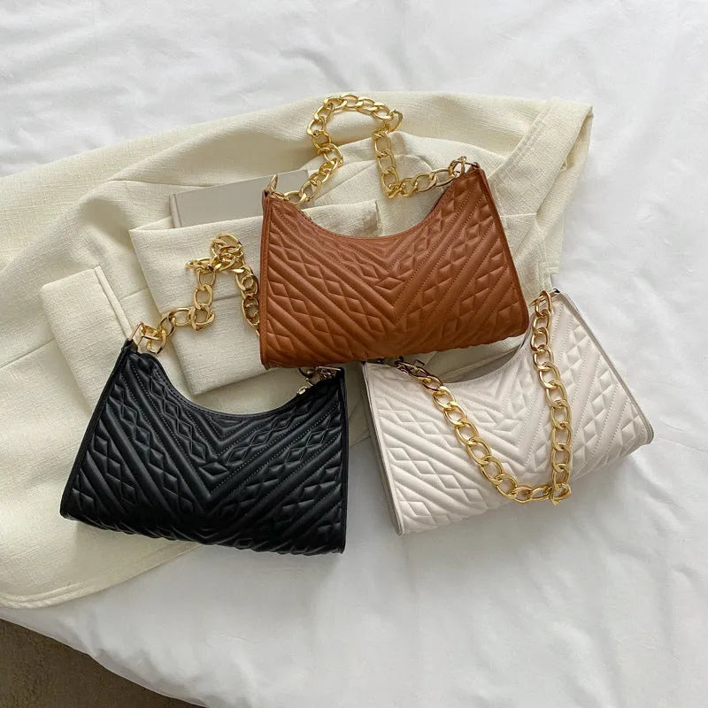 A women's black pleated chain baguette shoulder bag with a vertical square shape and an adjustable strap.