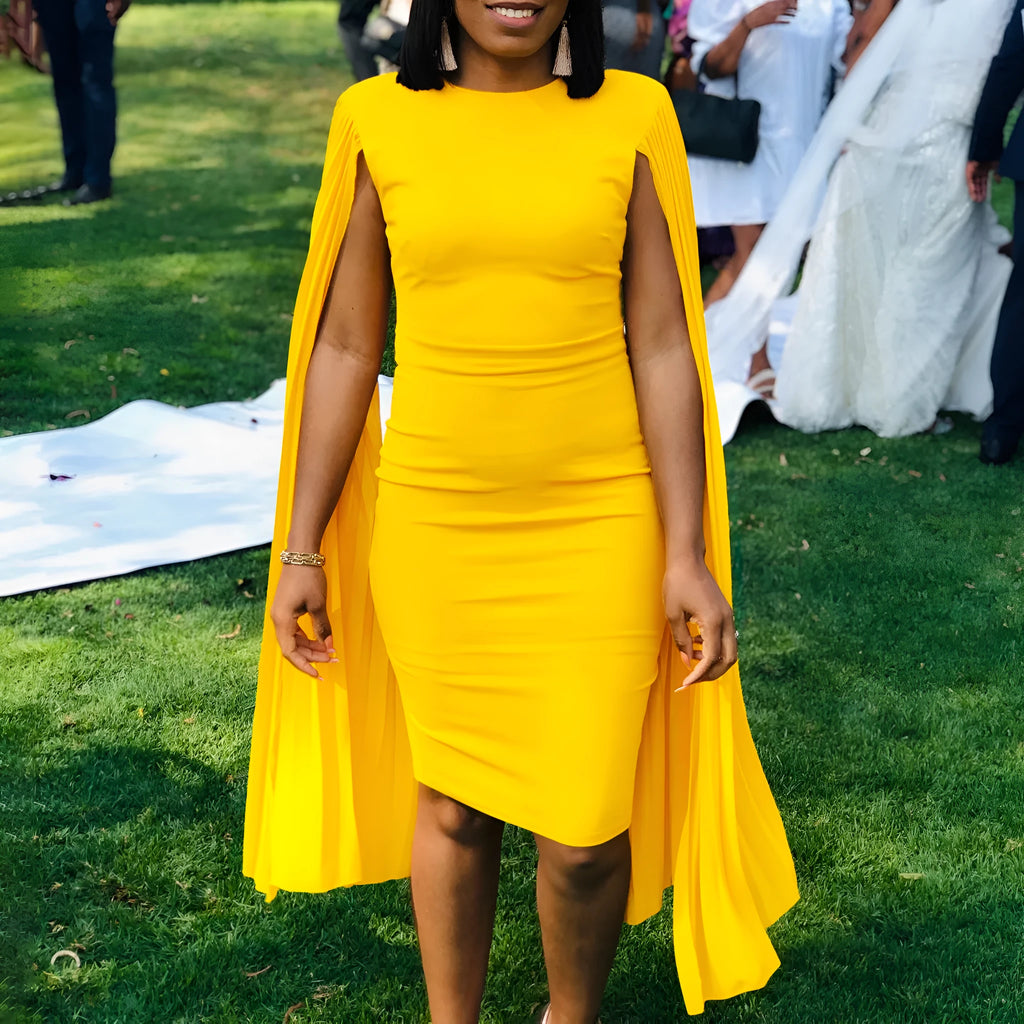 Yellow round neck long sleeve evening gown with a pleated shawl on a mannequin.