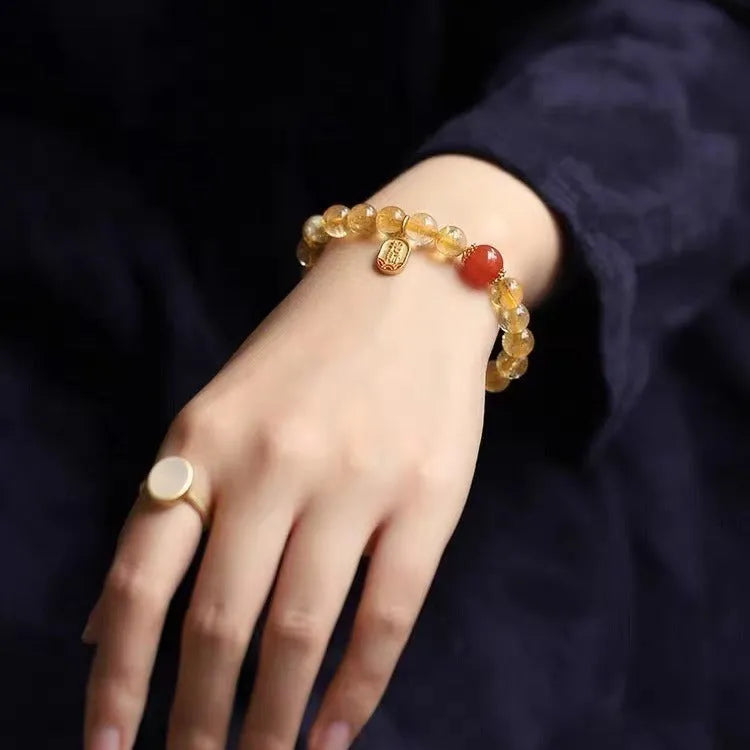 Natural red agate bracelet with gold-tone setting showing polished gemstone beads